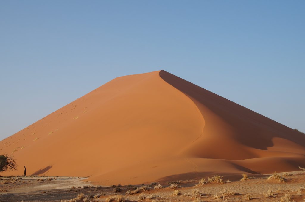Cone shaped red dune with footprints up the crest, Namibia