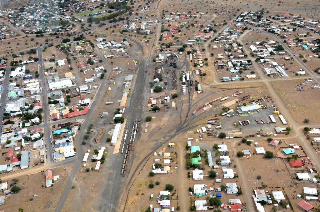 Aerial view over Keetmanshoop showing the long railway yard and goods sidings running through the middle of town, with grid streets and low houses on either side