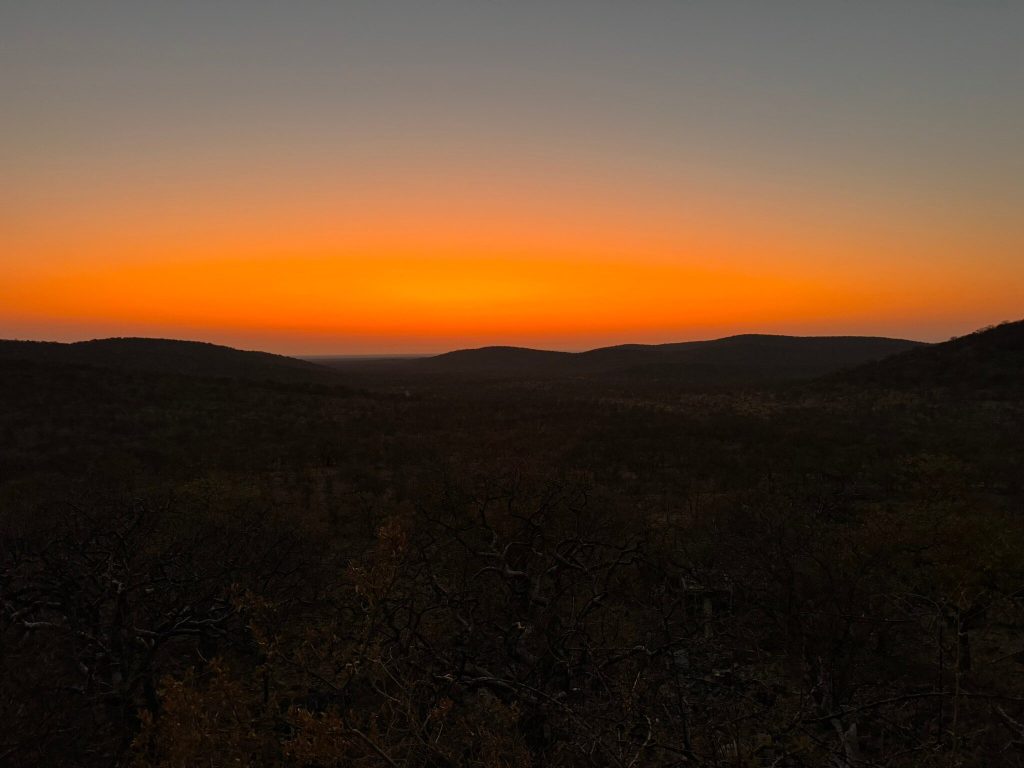 Orange afterglow over wooded hills at dusk, Namibia