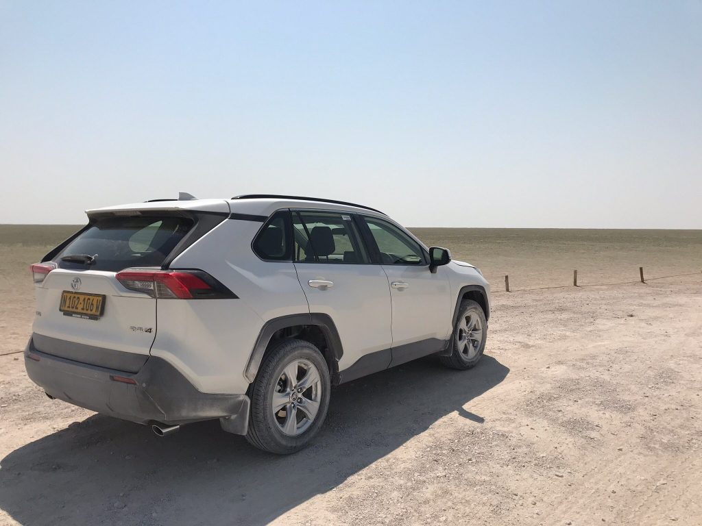 White Toyota RAV4 parked beside Etosha salt pan, Namibia